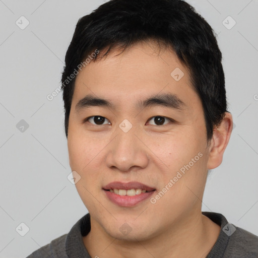 Joyful asian young-adult male with short  brown hair and brown eyes