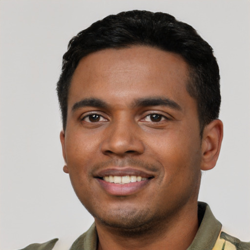 Joyful black young-adult male with short  black hair and brown eyes