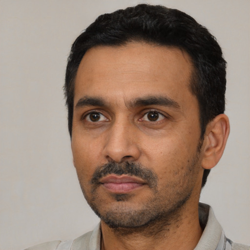 Neutral latino adult male with short  black hair and brown eyes