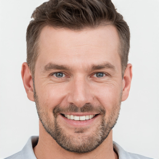 Joyful white young-adult male with short  brown hair and grey eyes