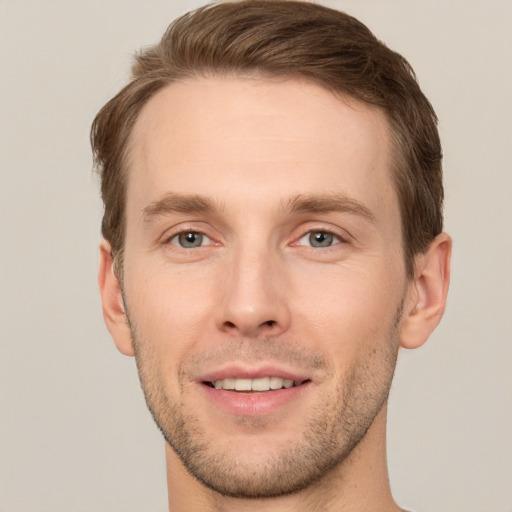 Joyful white young-adult male with short  brown hair and grey eyes