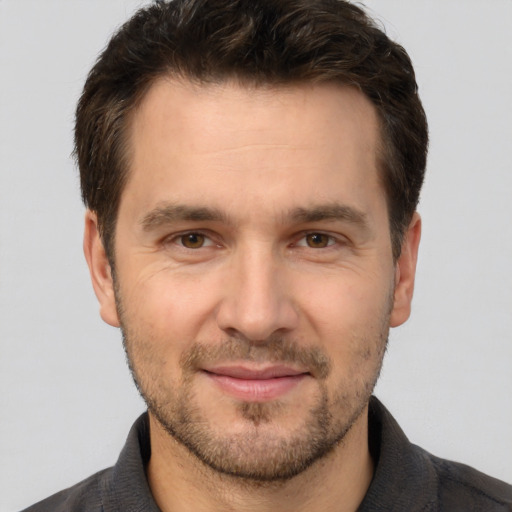 Joyful white adult male with short  brown hair and brown eyes