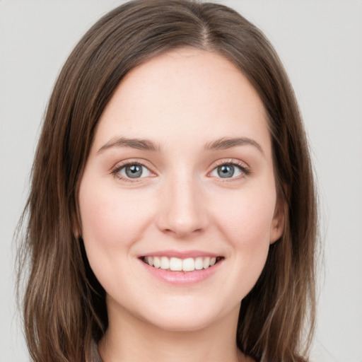 Joyful white young-adult female with long  brown hair and green eyes