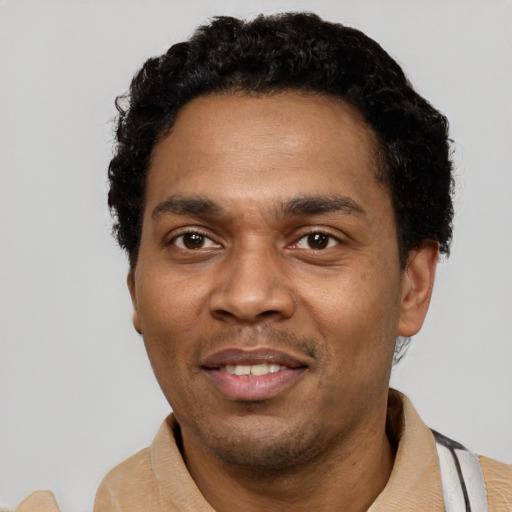 Joyful black young-adult male with short  black hair and brown eyes