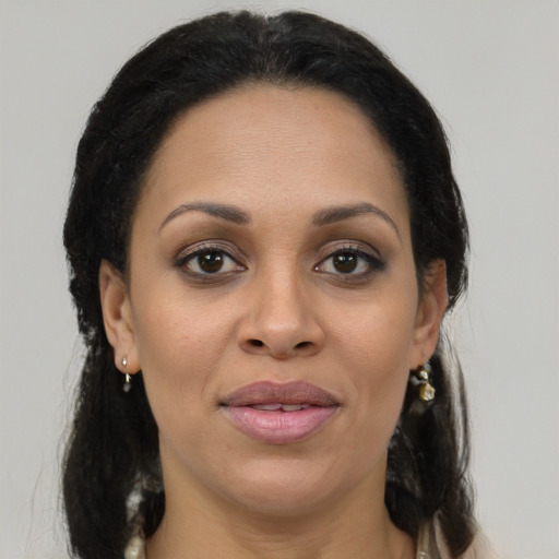 Joyful black young-adult female with long  brown hair and brown eyes