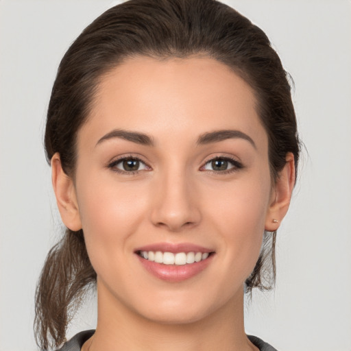 Joyful white young-adult female with medium  brown hair and brown eyes