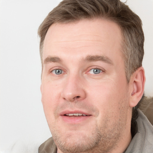 Joyful white adult male with short  brown hair and blue eyes