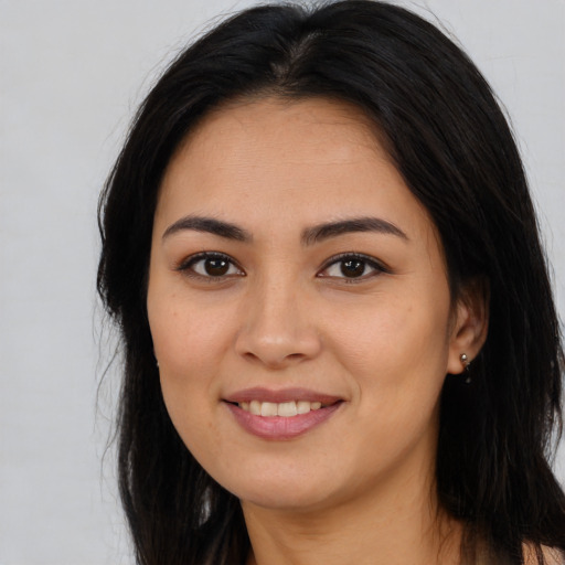 Joyful latino young-adult female with long  brown hair and brown eyes