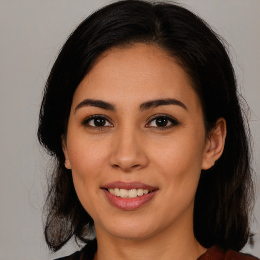 Joyful latino young-adult female with long  brown hair and brown eyes