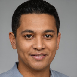 Joyful latino young-adult male with short  black hair and brown eyes