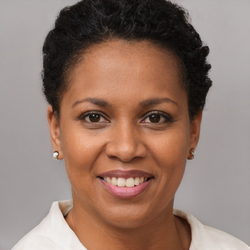 Joyful black young-adult female with short  brown hair and brown eyes
