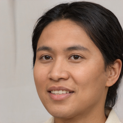 Joyful asian young-adult female with medium  brown hair and brown eyes