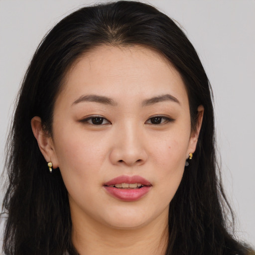 Joyful asian young-adult female with long  brown hair and brown eyes