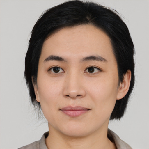 Joyful asian young-adult female with medium  black hair and brown eyes