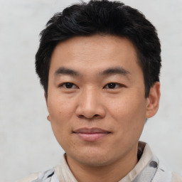 Joyful asian young-adult male with short  black hair and brown eyes