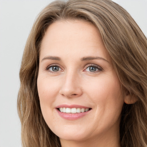 Joyful white young-adult female with long  brown hair and green eyes