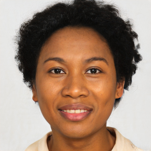 Joyful black young-adult female with short  black hair and brown eyes