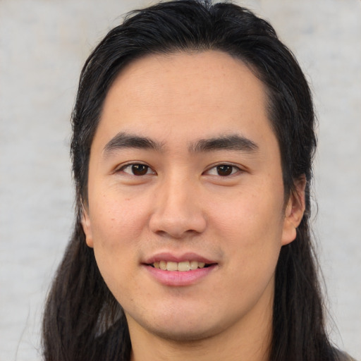Joyful white young-adult male with long  black hair and brown eyes