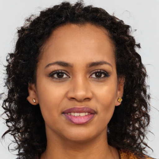 Joyful black young-adult female with long  brown hair and brown eyes