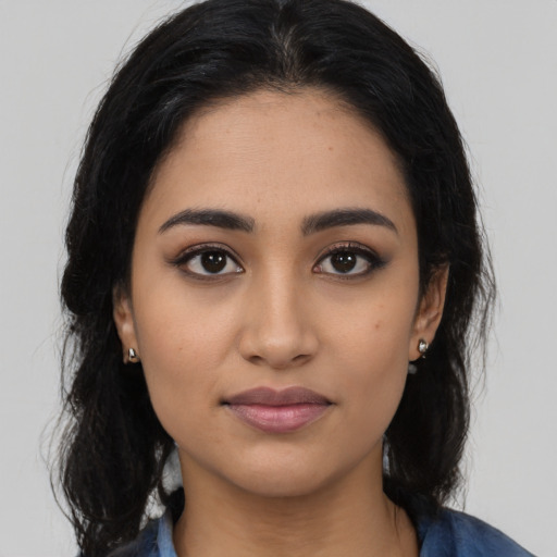 Joyful latino young-adult female with long  black hair and brown eyes