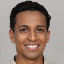 Joyful latino young-adult male with short  black hair and brown eyes