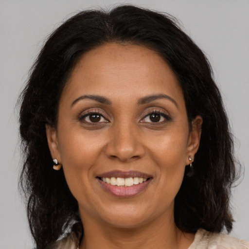 Joyful latino adult female with medium  brown hair and brown eyes