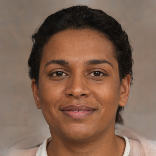 Joyful black young-adult female with short  brown hair and brown eyes