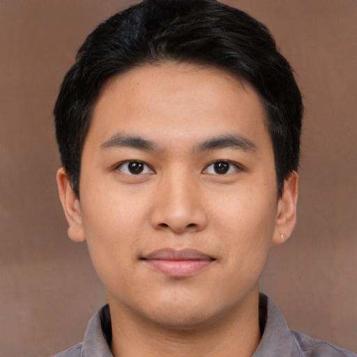 Joyful asian young-adult male with short  black hair and brown eyes