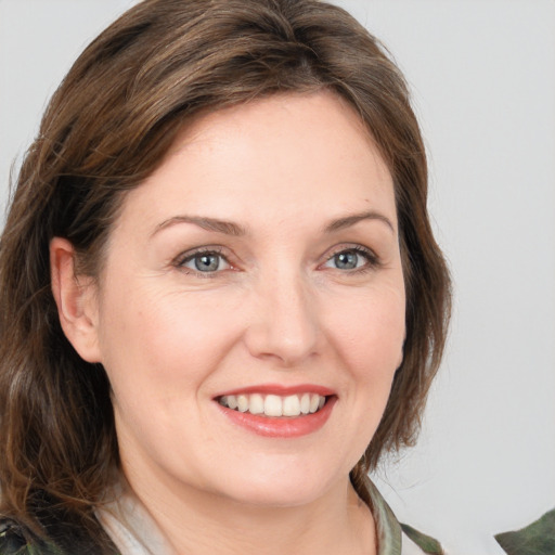 Joyful white young-adult female with medium  brown hair and green eyes