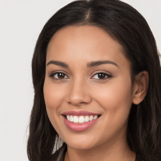 Joyful latino young-adult female with long  brown hair and brown eyes