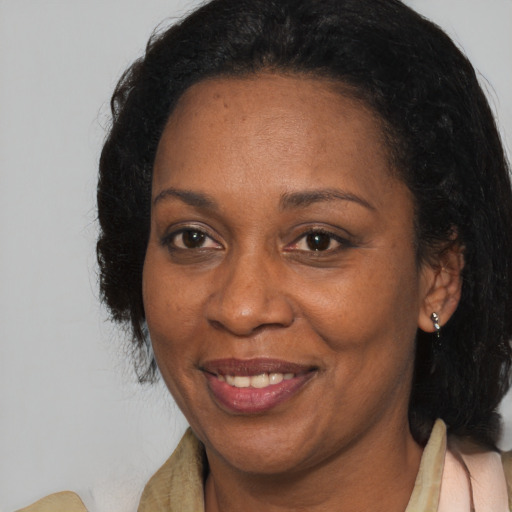 Joyful black adult female with medium  brown hair and brown eyes