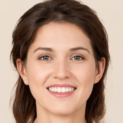 Joyful white young-adult female with long  brown hair and brown eyes