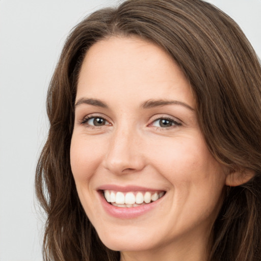 Joyful white young-adult female with long  brown hair and green eyes