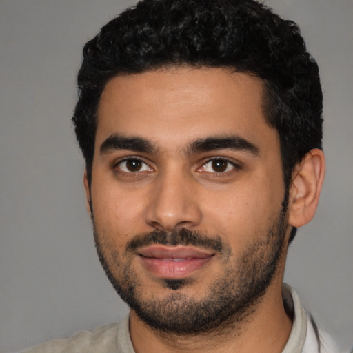 Joyful latino young-adult male with short  black hair and brown eyes