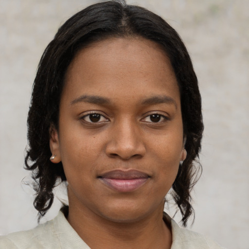 Joyful black young-adult female with medium  brown hair and brown eyes
