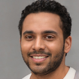 Joyful latino young-adult male with short  black hair and brown eyes