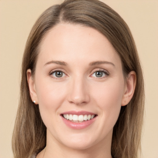 Joyful white young-adult female with long  brown hair and green eyes