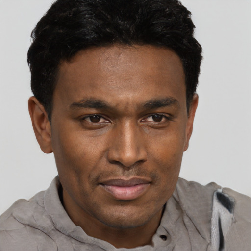 Joyful black adult male with short  brown hair and brown eyes