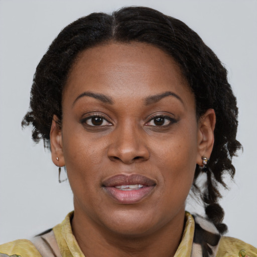 Joyful black adult female with medium  brown hair and brown eyes
