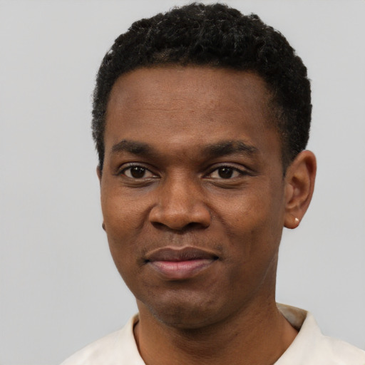 Joyful black young-adult male with short  black hair and brown eyes