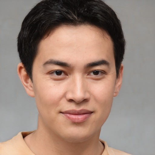 Joyful asian young-adult male with short  brown hair and brown eyes