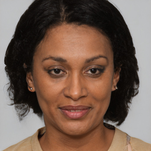 Joyful black adult female with medium  brown hair and brown eyes
