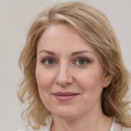 Joyful white adult female with medium  brown hair and blue eyes