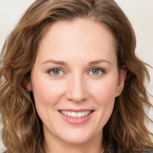 Joyful white young-adult female with long  brown hair and green eyes