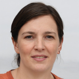 Joyful white adult female with medium  brown hair and grey eyes