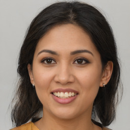 Joyful latino young-adult female with medium  brown hair and brown eyes