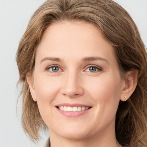 Joyful white young-adult female with long  brown hair and grey eyes