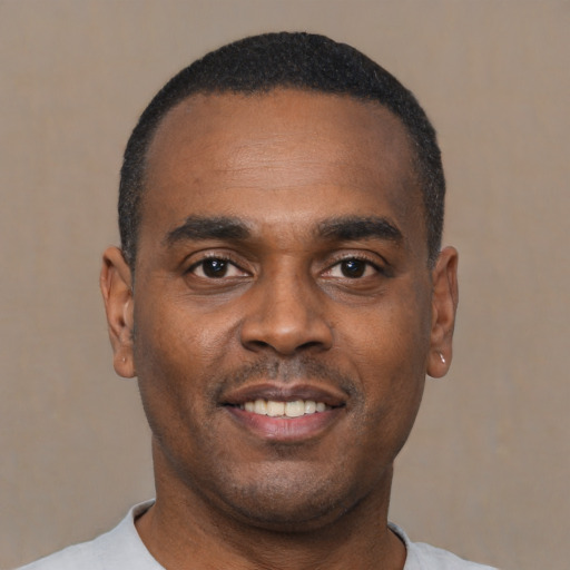 Joyful black young-adult male with short  black hair and brown eyes