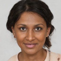 Joyful black young-adult female with medium  brown hair and brown eyes