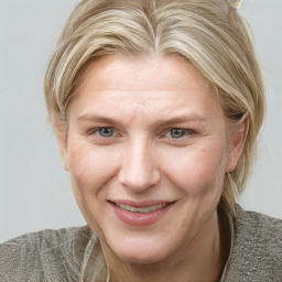 Joyful white adult female with medium  brown hair and blue eyes